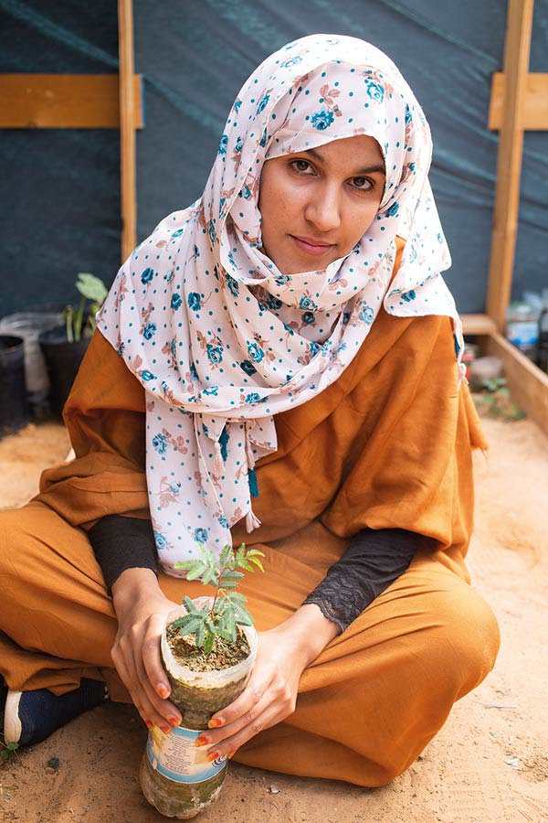 a woman holding a sapling