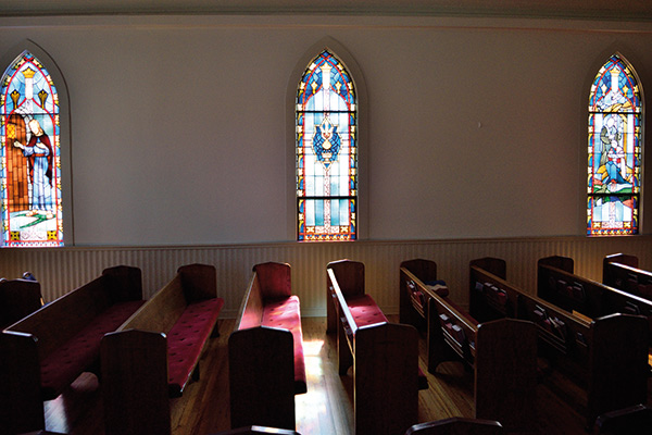 church pews below stained glass windows