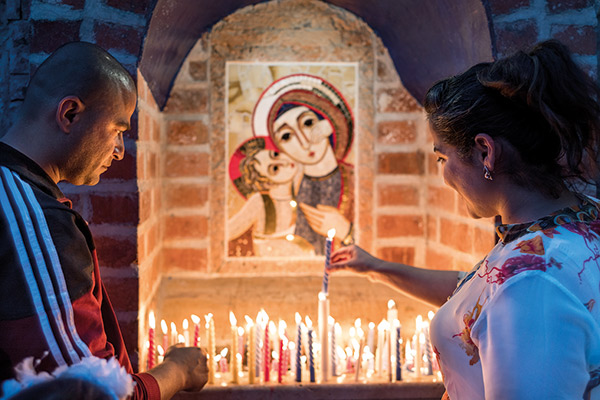 Christians lighting candles in a monastery