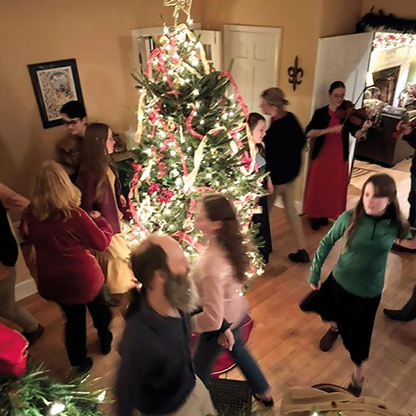 family around a lit christmas tree