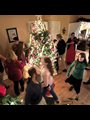 family around a lit christmas tree