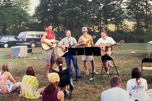 four people playing music at a potluck
