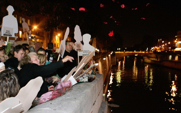 demonstrators throwing rose petals into a river