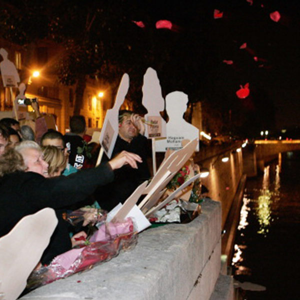demonstrators throwing rose petals into a river