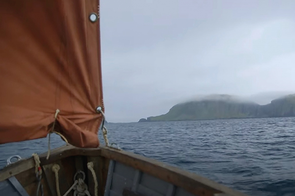 sailboat sailing towards some islands