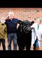 a few people posing for a photo with a cow