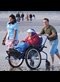 elderly person being pushed in a wheelchair by the beach