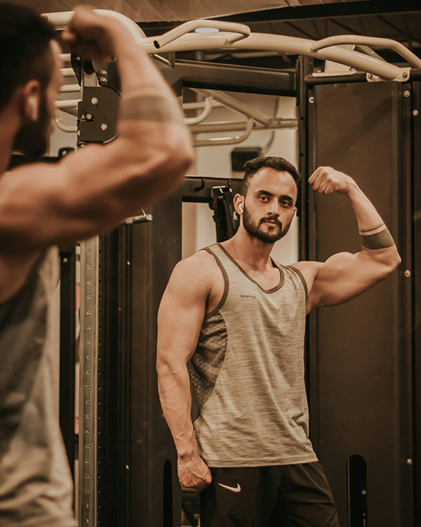 a man in a gym flexing his arm