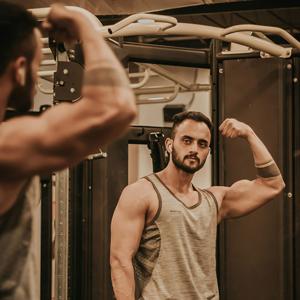 a man in a gym flexing his arm