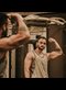 a man in a gym flexing his arm