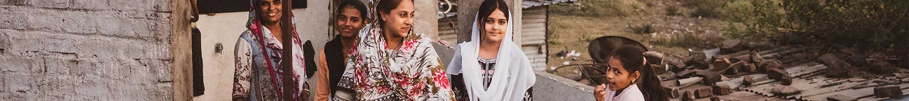 people standing by a stone wall