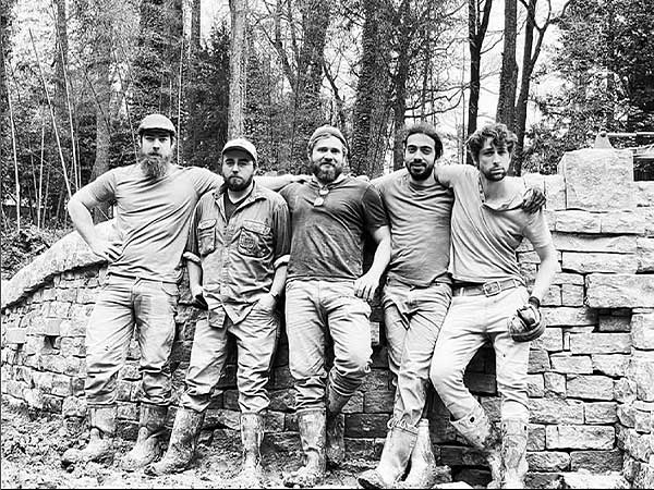five men standing by a house