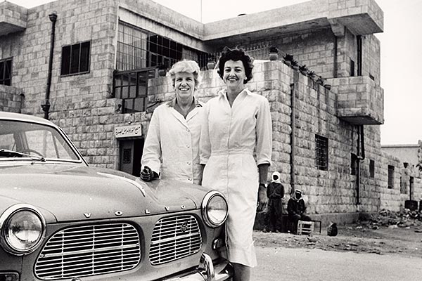a couple standing by a car