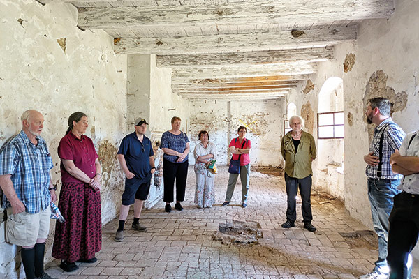 a group standing in the ruins of a former Hutterite community
