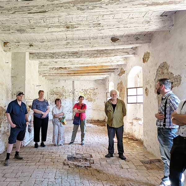 a group standing in the ruins of a former Hutterite community