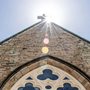 sun shining on the roof of a church