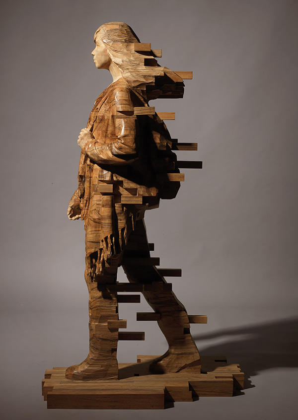 wood sculpture of a woman walking