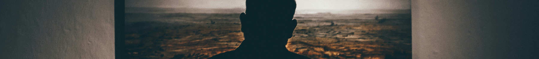 a man looking at a painting on a wall