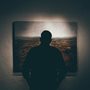 a man looking at a painting on a wall