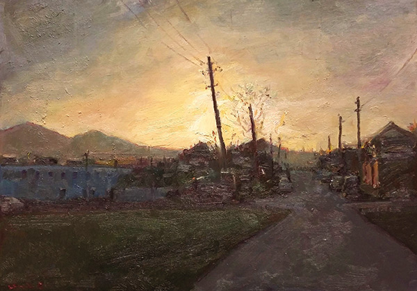 sun setting over a country village