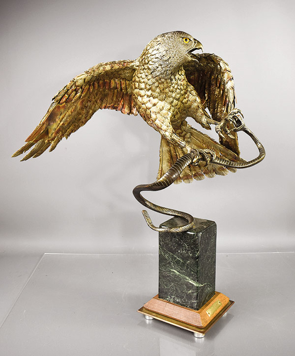 stainless steel sculpture of a hawk catching a snake