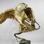 stainless steel sculpture of a hawk catching a snake