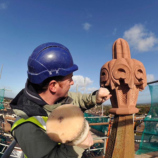 a stonemason working on a church roof