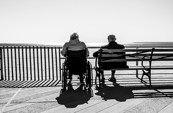 two old people sitting by the ocean