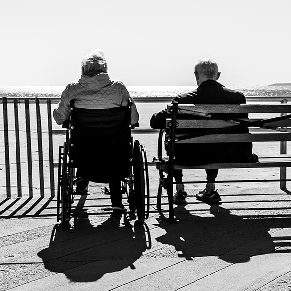 two old people sitting by the ocean