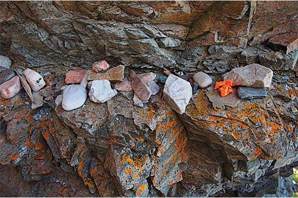 Small rocks placed on the Áhkku sieidi rock formation near Alta, Norway